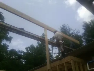 Carpenter setting a ridge beam over a new addition frame — Ice Dam Removal by Roofing Brothers in Winfield