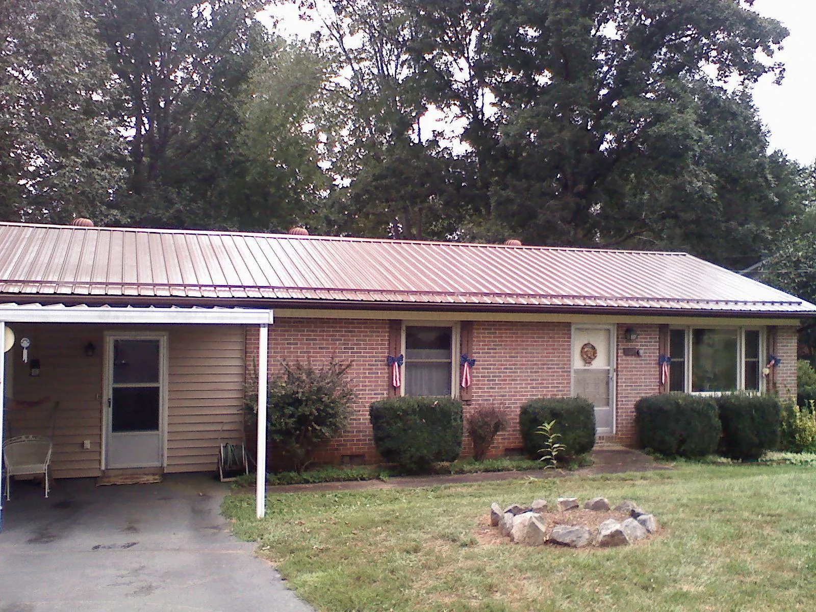 Bronze metal roof and carport on a brick ranch home — Roof Repair work by our crew in Winfield